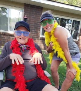 Dress Up Day at Breath of Life with people wearing boa's and fun glasses outside on a hot day.
