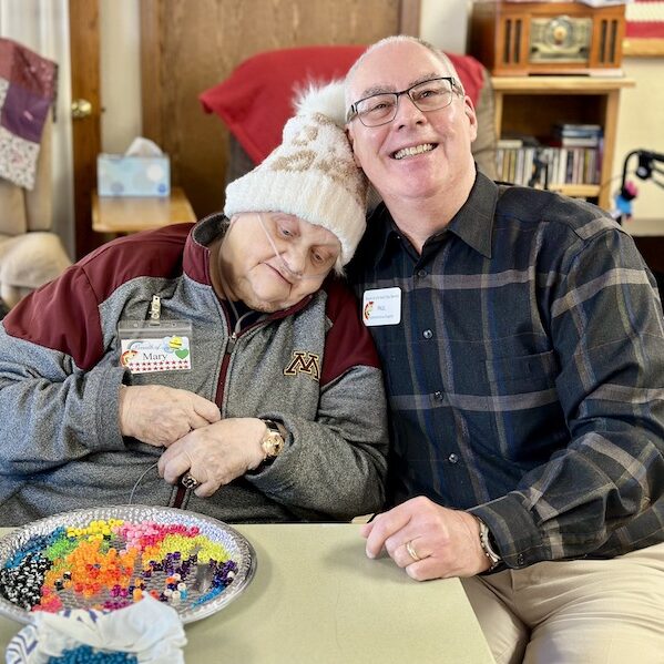 Paul and Mary sitting at a table with a bead activity.
